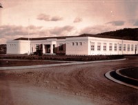 Photo shows a curbed and guttered gravel drive leading to the front entrance of the Ainslie Public School in Elourea Stree, Braddon.