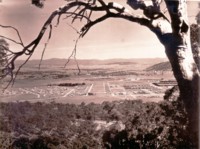 View from Mt Ainslie showing the Hotel Ainslie, houses in the foreground and Civic in the distance. Gorman House is in the middle distance and St. John's Church can be seen amongst a clump of trees.