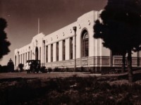 A view of the Institute of Anatomy taken from the left front corner. It shows a car at the entrance with a man in a white dust coat leaning against the car.