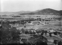 A photograph taken from Red Hill showing the Molonglo River flowing through the centre with the suburbs of Reid and Ainslie in the distance.