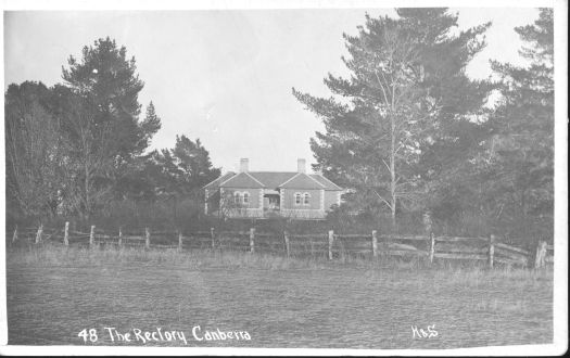 A front view of the Rectory, Canberra with trees on either side