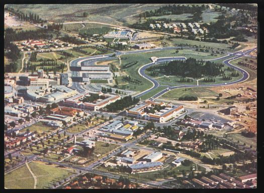 Aerial view of Canberra's expanding shopping and business district. Text on card: \"The Town House Motel is three minutes walk of shops and Tourist Bureau.\"
