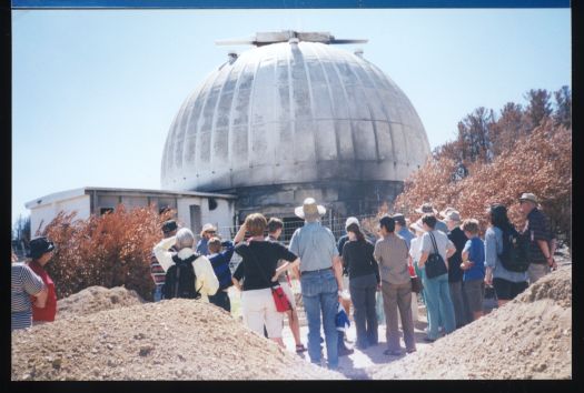 Group of people in front of bush fired damaged Observatory Mt Stromlo