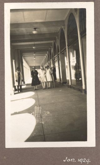 Three unknown women walking in front of the shops

