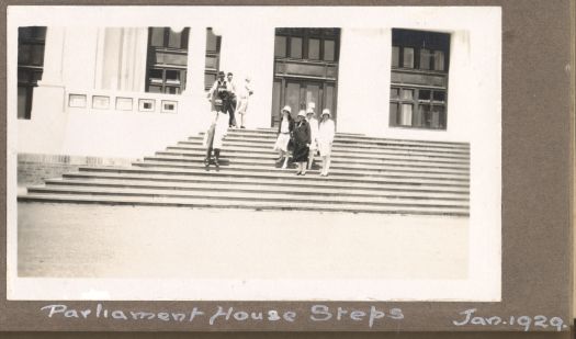 Five women and three men standing on the steps of Parliament House