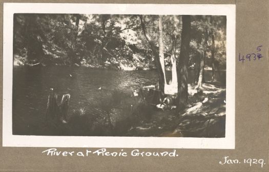 The river at the picnic ground with some people swimming