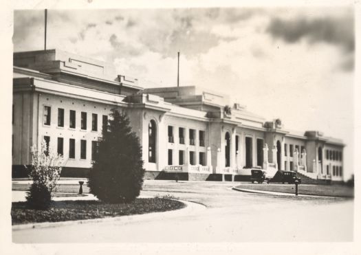 The front of Parliament House with two cars parked in front
