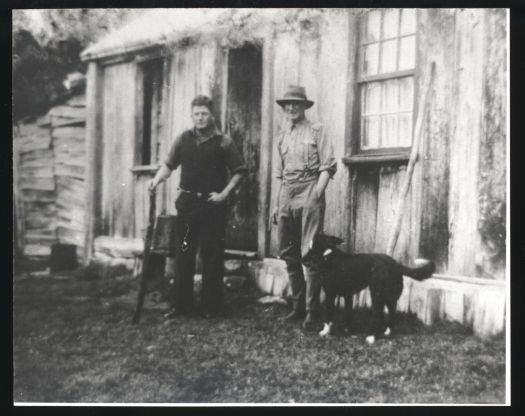 Cotter Homestead with Cecil Dawes and Jack Maxwell with dog standing in front of Cotter Homestead.