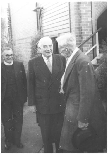 An elderly Sir Robert Garran talking to Prime Minister Robert Menzies at the laying of the foundation stone for the gymnasium at the Girls Grammar. W.J. Edwards is behind Menzies.