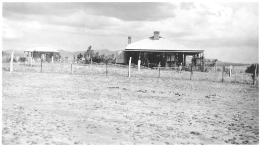 Bonshaw homestead shown with verandah, few young trees and dry grass. A smaller cottage is at left. Bonshaw was the property of John Garran, son of Robert Garran, and is situated along Canberra Avenue near HMAS Harman.