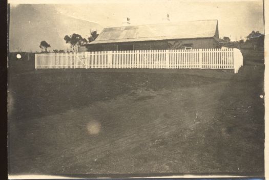 Mr Barnett's home with a white painted paling fence in front