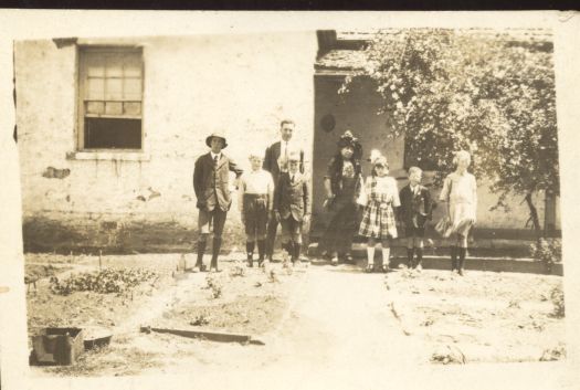 Carwoola school with the teacher and seven students standing in front of school