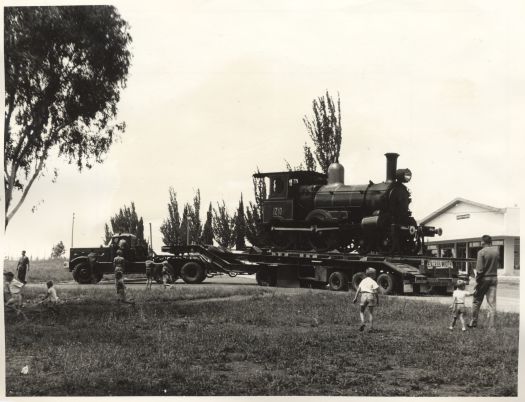 Railway engine 1210 being loaded on lorry for removal to the siding plinth near the Canberra Railway Station, facing Wentworth Avenue.