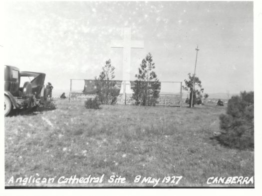 Anglican Cathedral site on Rottenbury Hill showing a Christian cross with cars at the left