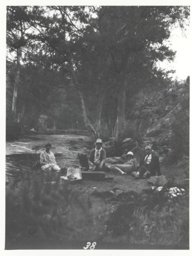 Two unidentified couples having a picnic by the river