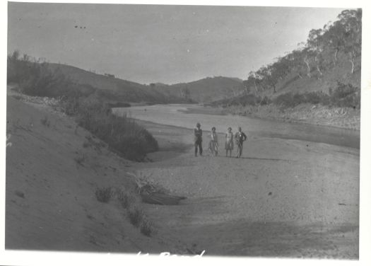 Two women and two men standing on the sandy bank at Angle Crossing