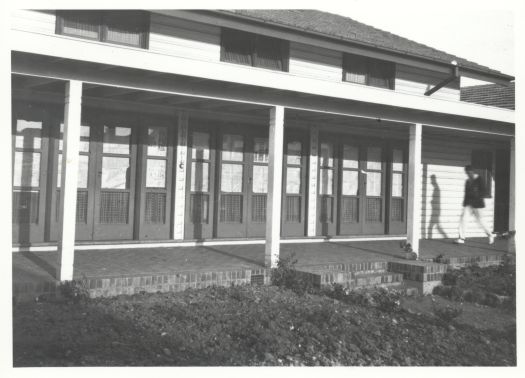 Close up of the front of the Hotel Ainslie, later called Gorman House, with a man walking across the front