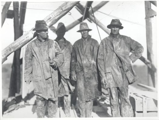 Four sewer main workers with their water proof clothing