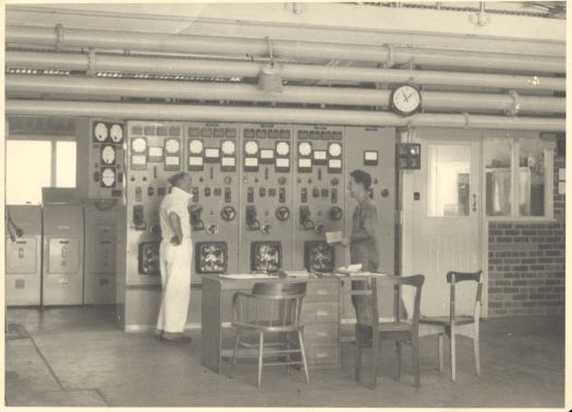Canberra Diesel Power Station which operated 1953-1980. Shows two men standing in front of the Main Control Board.