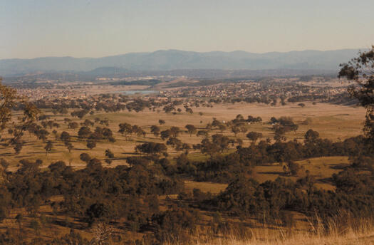 View from Oak Hill (benchmark HL119) to the south west showing Ngunnawal, Gungahlon Pond, Nicholls in the distance. Horse Park is visible in the middle of the photo.