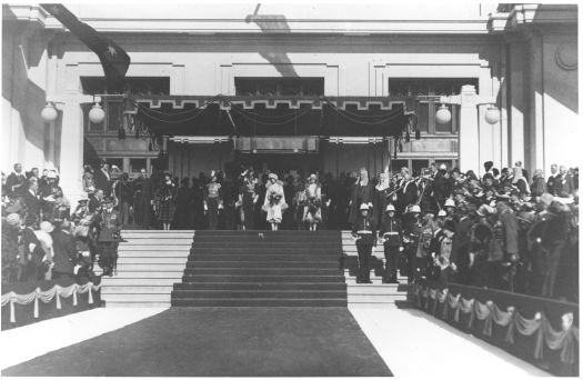 Duke and Duchess of York on the steps of Parliament House. People are standing and the Duke is saluting.