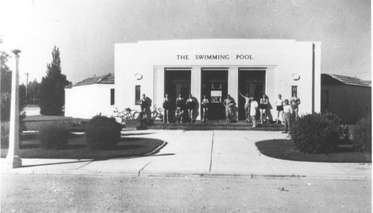 Front entrance of the Manuka Pool showing 13 men and women in front, some in swimming costumes.