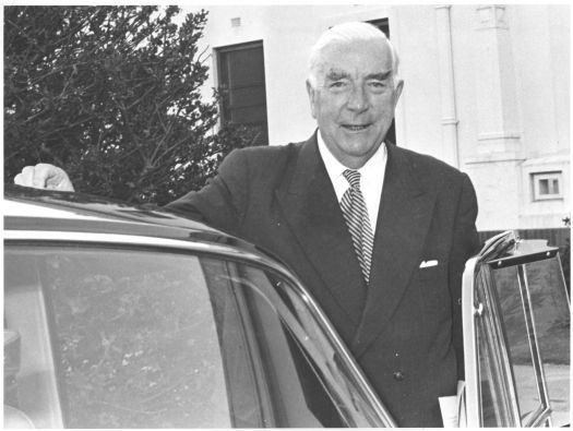 Prime Minister Robert Menzies at the door of a car near Parliament House.