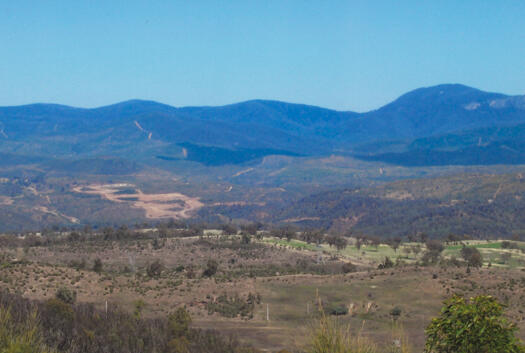 Distant view of the Cotter Dam construction from Mt Stromlo