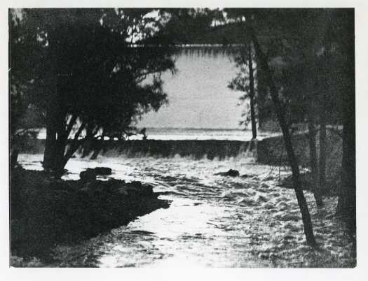 The Cotter River is in flood and water is flowing over the Cotter Dam wall