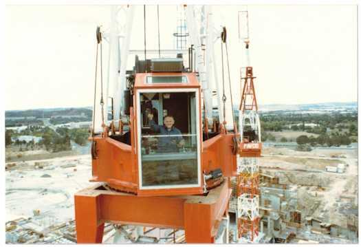 Operator of a crane operator waving at the photographer. Brisbane Avenue is visible at left.