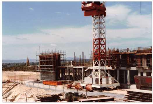 View of a Favco crane working on the House of Reps side of the building. St Andrew's Cathedral is at left.