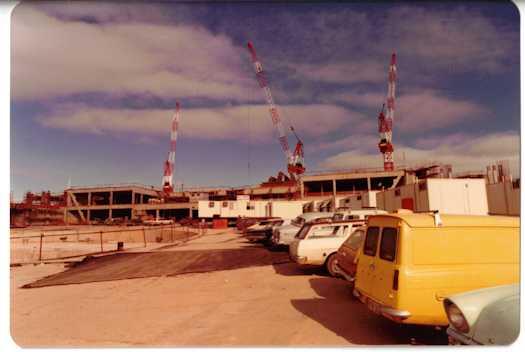 Ground view of workers car park with building work in the background