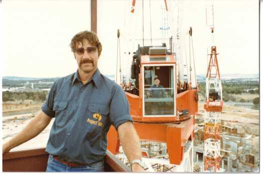 Bob Taylor standing in a crane dog box. Crane and operator (possibly Alf Chambers) can be seen at rear.