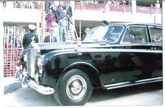 Prince and Princess of Wales walking down temporary stairs towards their Rolls Royce