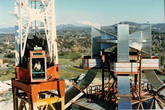 Close view of the flag pole hub and adjacent crane with operator looking at the camera