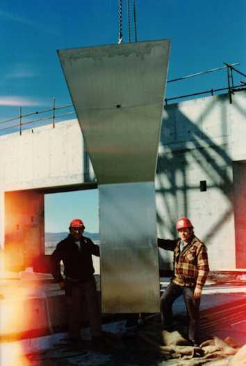 Two workmen with part of the flag pole