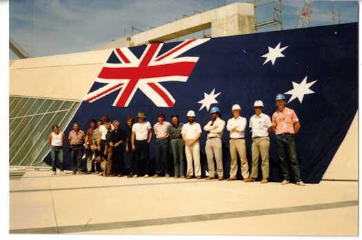 Group photo of flag mast construction team - seventeen men plus Two Bob the dog