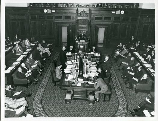 Prime Minister Whitlam standing and opposition leader Billy Snedden seated in the House of Representatives chamber.