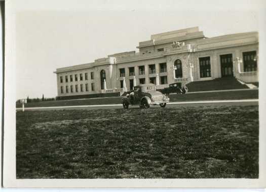 Front of Parliament House showing two cars c1920s
