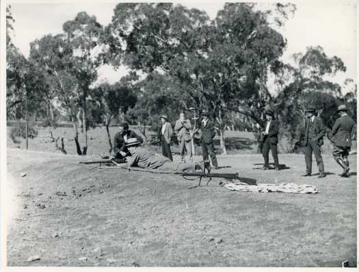 One man preparing to take aim whilst 7 others stand around.