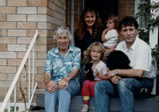 Pat sitting on steps of a house in Auckland with Honor's younger son Andrew and his wife Lesley and daughter Vicky and a younger daughter.