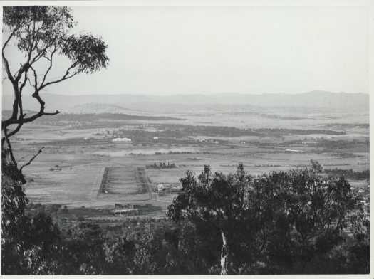 Shows Ainslie Hotel and St John's Church to right of Anzac Parade. Brindabella hills in distance.
