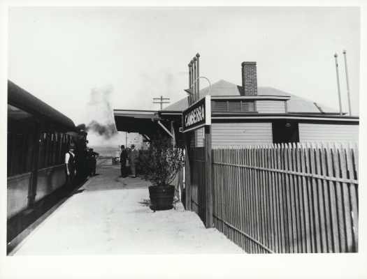 Train guard and some passengers on the platform.