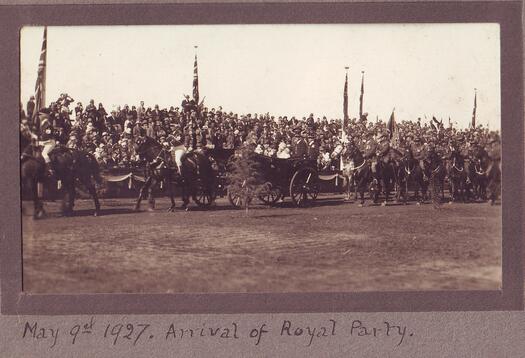 The arrival at Parliament House on 9 May 1927 of the Duke and Duchess of York in their carriage, accompanied by soldiers on horses, with the crowd in the background