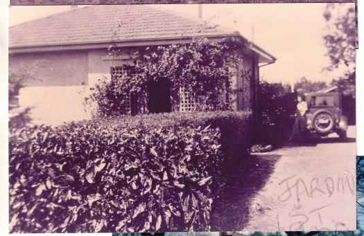 Third of a series: 1923, 1933, 1937 and 1950s. Womanand car in driveway and vigouous rambling rose at front.