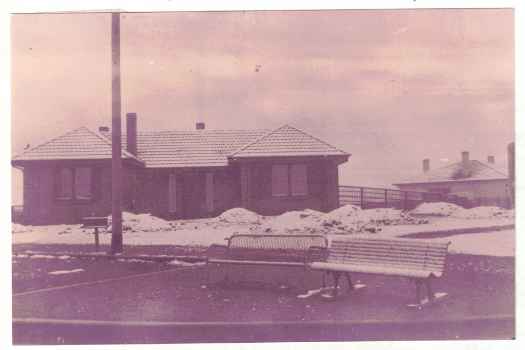 Snow covered garden of house. Cornerr Giles and Jardine Streets. Shows early bus stop seats. See notes.