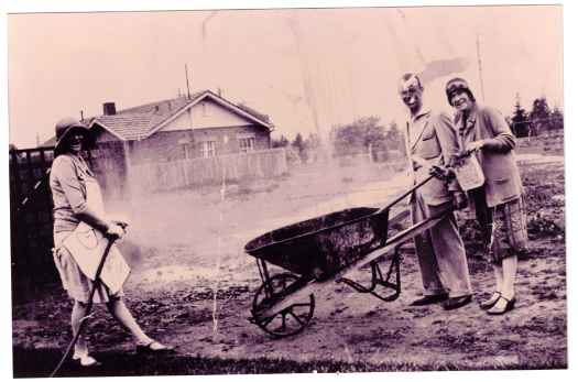 Ian and Madge with wheelbarrow and another person on the left.
