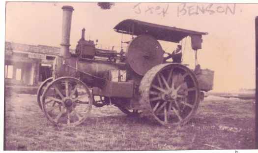 Shows traction engine in front of shops under construction. The driver could have been Bill Wilkinson or George Dickson.