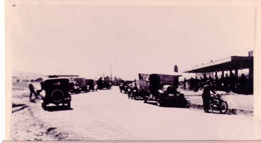 Shows shops on right and a variery of vehicles on Giles Street. 