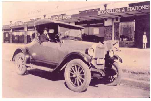 Car and unidentified driver parked outside the shop. 
